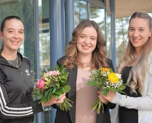 Glückwünsche zum Abschluss mit Bestnoten: Johanna Schmitt (mitte) aus der Personalabteilung überreicht Linda Rauch (links) und Laura Kaßecker (rechts) zum jeweils sehr guten Abschluss einen Blumenstrauß.