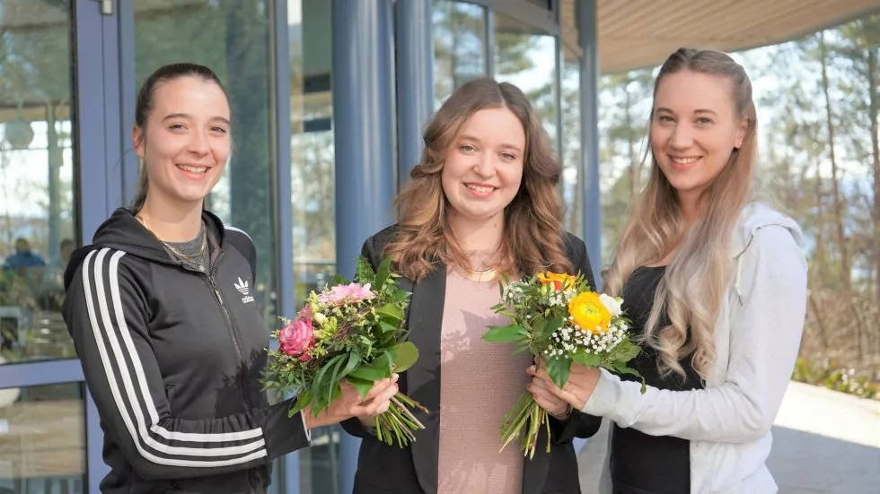 Glückwünsche zum Abschluss mit Bestnoten: Johanna Schmitt (mitte) aus der Personalabteilung überreicht Linda Rauch (links) und Laura Kaßecker (rechts) zum jeweils sehr guten Abschluss einen Blumenstrauß.